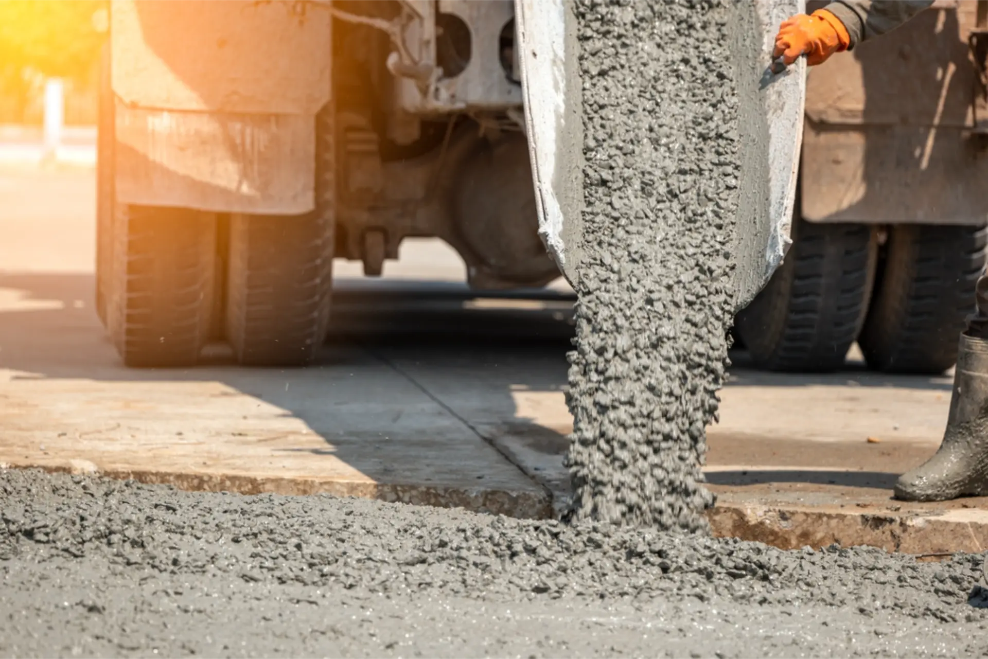 A worker guiding concrete down the truck chute into the formwork