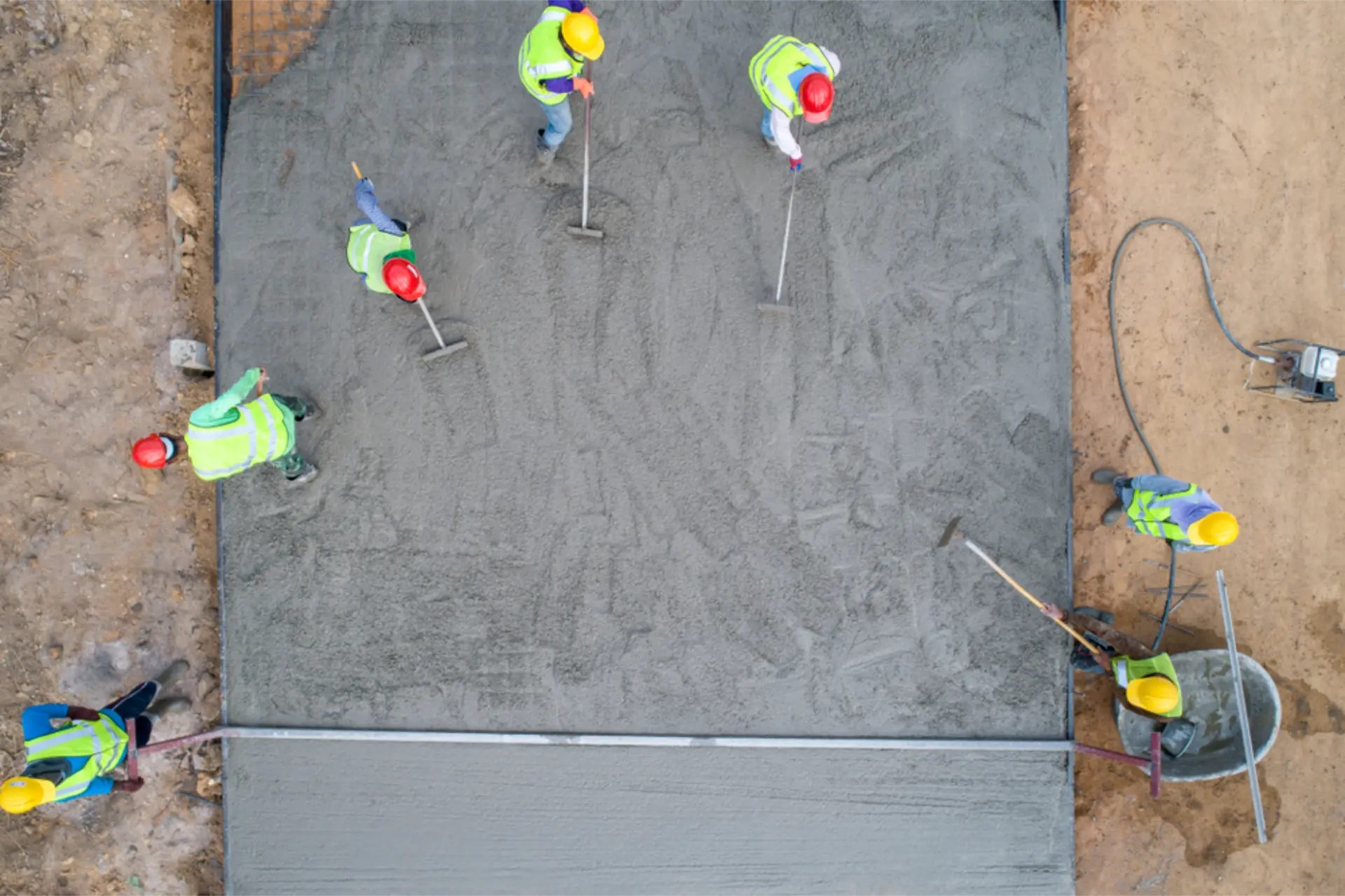 Aerial view of a crew finishing a large freshly poured concrete slab