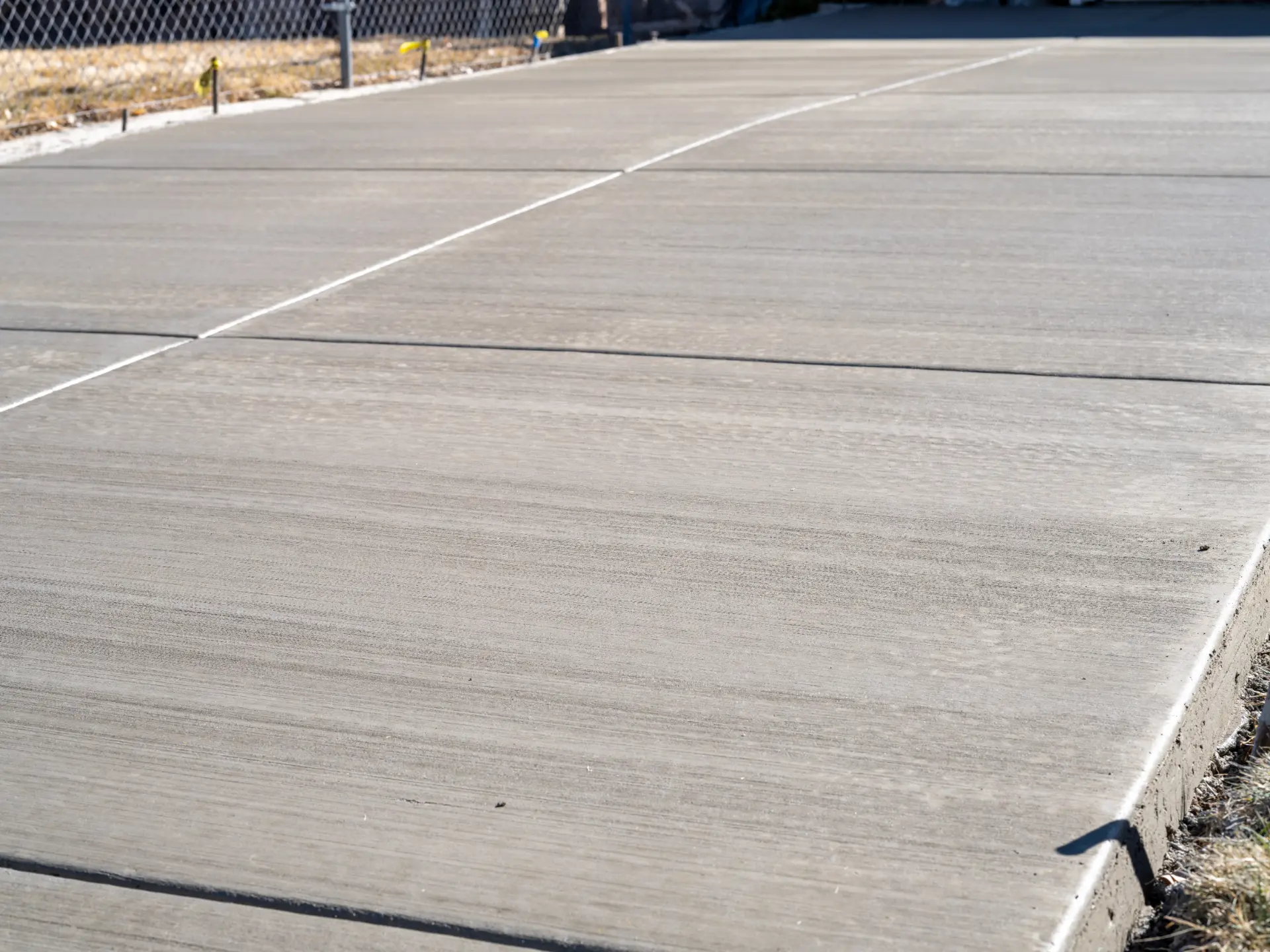 A broom-finished concrete path with cut expansion joints