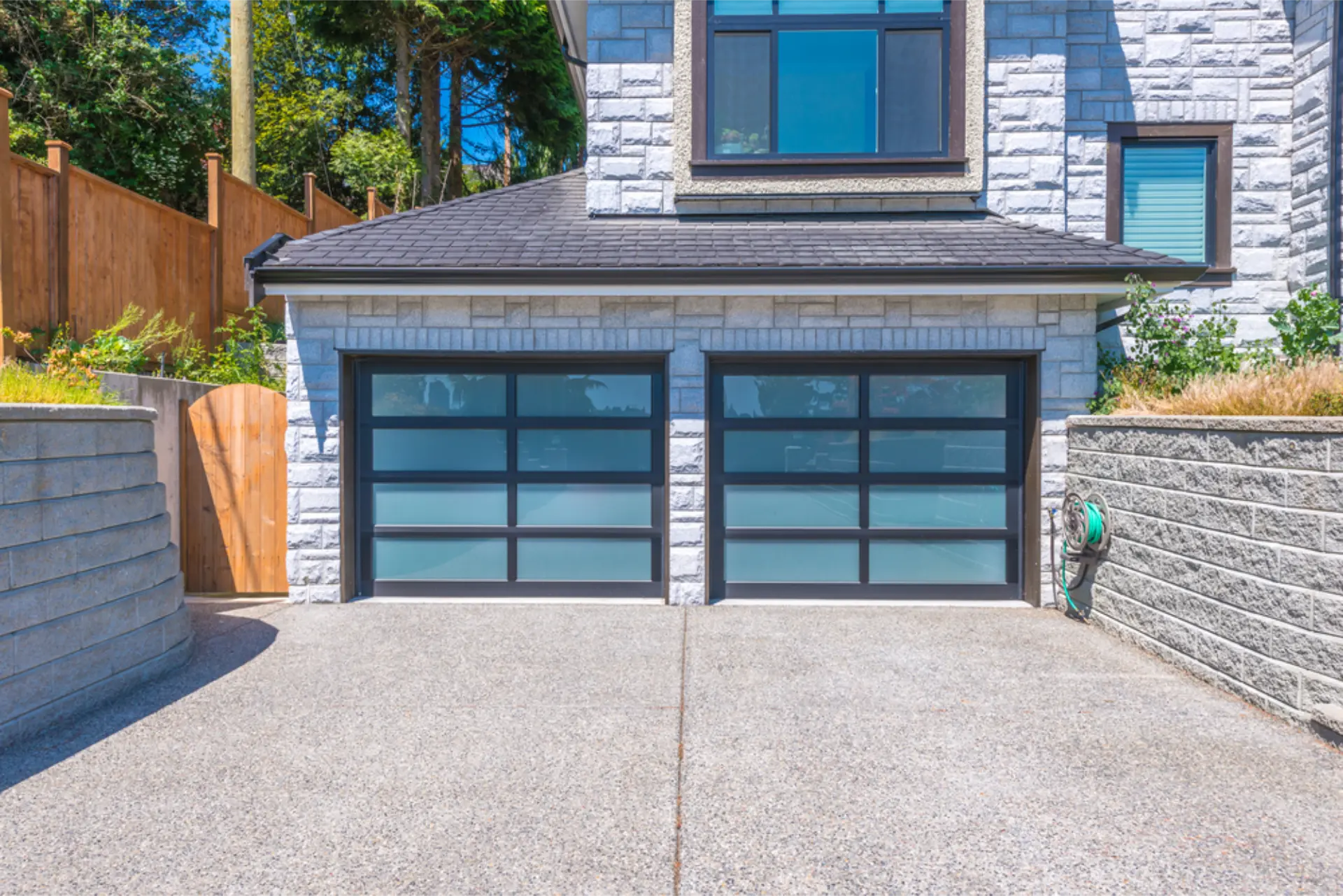 A finished concrete driveway in front of glass-panel garage doors